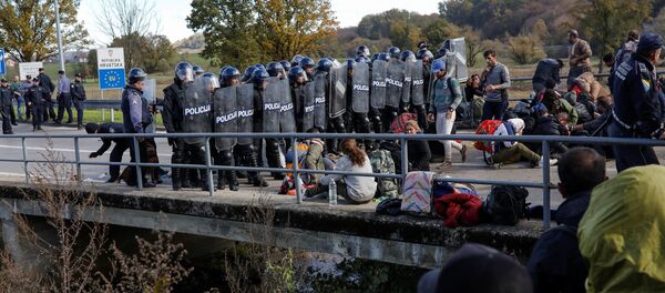 Croatian riot police stand guard in front of migrants at Maljevac border crossing between Bosnia and Croatia near Velika Kladusa, Bosnia, October 24, 2018. Croatian riot police stand guard in front of migrants at Maljevac border crossing between Bosnia and Croatia near Velika Kladusa, Bosnia, October 24, 2018. - Sputnik Afrique