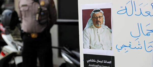 Un manifestant tenant une pancarte avec la photo de Jamal Khashoggi - Sputnik Afrique
