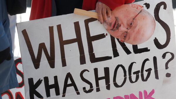 An activist holds a sign and image of missing Saudi journalist Jamal Khashoggi during a demonstration calling for sanctions against Saudi Arabia and to protest Khashoggi's disappearance, outside the White House in Washington, U.S., October 19, 2018 - Sputnik Afrique