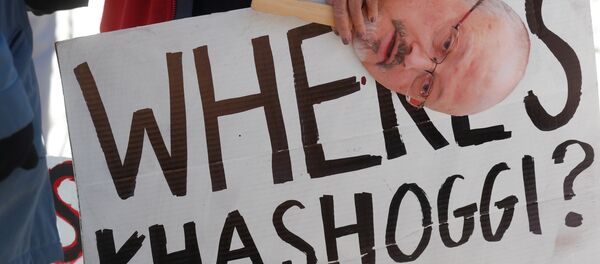 An activist holds a sign and image of missing Saudi journalist Jamal Khashoggi during a demonstration calling for sanctions against Saudi Arabia and to protest Khashoggi's disappearance, outside the White House in Washington, U.S., October 19, 2018 - Sputnik Afrique
