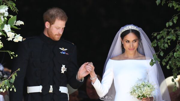 Britain's Prince Harry, Duke of Sussex and his wife Meghan, Duchess of Sussex emerge from the West Door of St George's Chapel, Windsor Castle, in Windsor, on May 19, 2018 after their wedding ceremony. - Sputnik Afrique