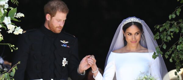 Britain's Prince Harry, Duke of Sussex and his wife Meghan, Duchess of Sussex emerge from the West Door of St George's Chapel, Windsor Castle, in Windsor, on May 19, 2018 after their wedding ceremony. - Sputnik Afrique