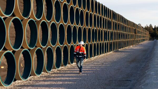 Ein Bauarbeiter vor den Metallröhren für die Gaspipeline Nord Stream 2 (Archivbild) - Sputnik Afrique