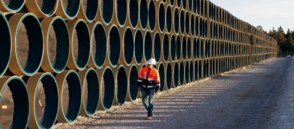 Ein Bauarbeiter vor den Metallröhren für die Gaspipeline Nord Stream 2 (Archivbild) - Sputnik Afrique