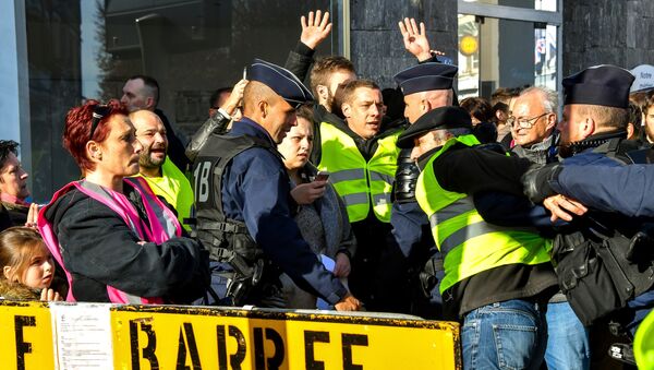 Anti-riot policemen evacuate protesters wearing yellow jackets (gilets jaunes) during a protest against the rising of the fuel and oil prices on November 9, 2018 near the town hall of Albert, northern France, ahead of a visit of tyhe French president and the Britain Prime minister during the 100 anniversary of the WWI armistice celebrations. - Sputnik Afrique