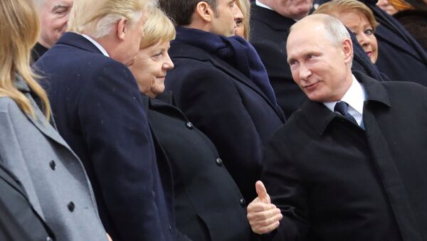 Russian President Vladimir Putin talks with German Chancellor Angela Merkel and U.S. President Donald Trump as they attend a commemoration ceremony for Armistice Day, 100 years after the end of the First World War at the Arc de Triomphe, in Paris, France, November 11, 2018. - Sputnik Afrique