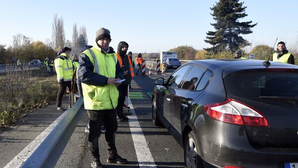 A demonstrator of the Yellow Vests movement (Gilets Jaunes) distributes tracts to a car driver on November 18, 2018 at the border point with Belgium in Crespin near Valenciennes, northern France, a day after a nationwide protest against high fuel prices. - Sputnik Afrique