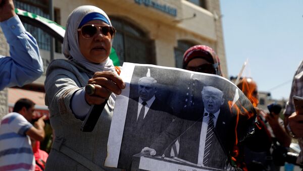 A Palestinian woman burns a picture of U.S. President Donald Trump and Israeli Prime Minister Benjamin Netanyahu during a protest against a U.S. decision to cut funding to the United Nations Relief and Works Agency (UNRWA), in Ramallah, in the occupied West Bank September 4, 2018.  - Sputnik Afrique