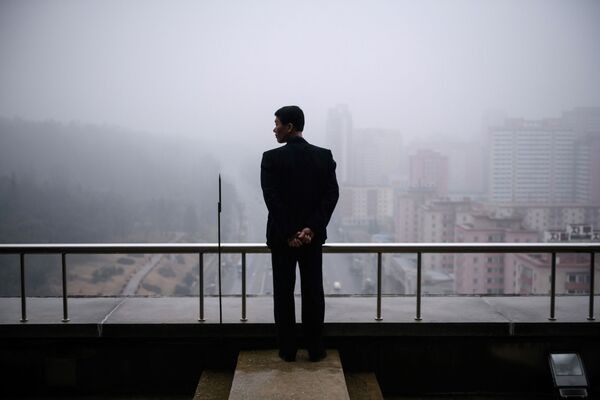 Un homme sur un balcon à Pyongyang, Corée du Nord. - Sputnik Afrique