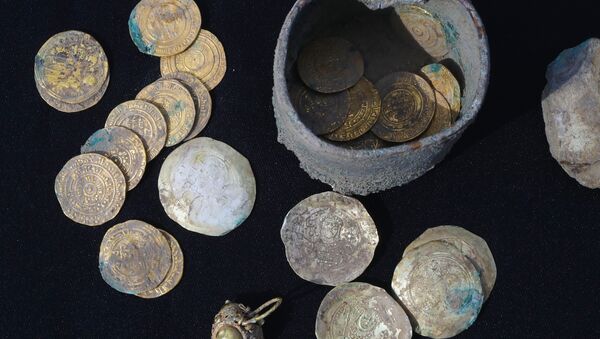 Un pot contenant 24 pièces d’or et des boucles d’oreille du même métal retrouvé lors de fouilles dans un quartier ancien de la ville israélienne de Césarée - Sputnik Afrique