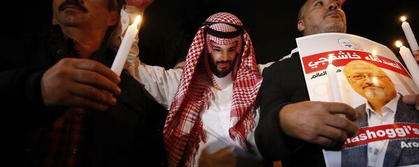 An activist, wearing a mask depicting Saudi Crown Prince Mohammed bin Salman, holds up his hands, painted with fake blood as he protests the killing of Saudi journalist Jamal Khashoggi, during a candlelight vigil outside Saudi Arabia's consulate in Istanbul, Thursday, Oct. 25, 2018 - Sputnik Afrique