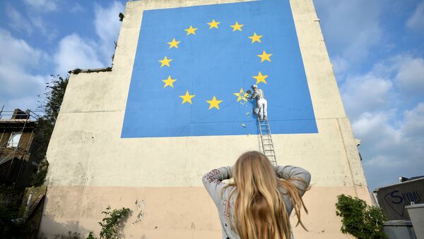 A young girl looks at artwork attributed to street artist Banksy, depicting a workman chipping away at one of the 12 stars on the European Union, seen on a wall in the ferry port of Dover, Britain, May 7, 2017. - Sputnik Afrique