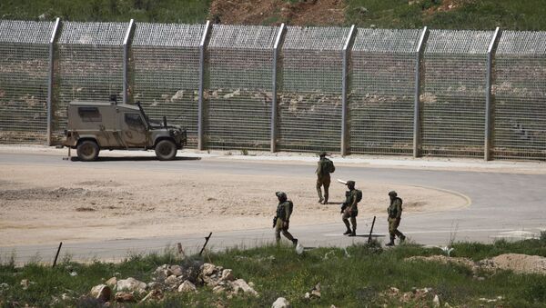 Israeli soldiers walk near a fence in the Israeli occupied Golan Heights on the border with war-torn Syria - Sputnik Afrique