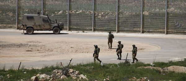Israeli soldiers walk near a fence in the Israeli occupied Golan Heights on the border with war-torn Syria - Sputnik Afrique