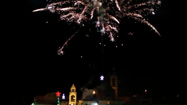 Christian Palestinians launch fireworks to celebrate the lighting of a Christmas tree at Manger Square, outside the Church of the Nativity in the West Bank town of Bethlehem - Sputnik Afrique