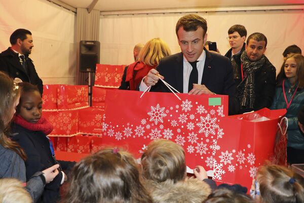 Emmanuel Macron distribue des cadeaux aux enfants Emmanuel Macron distribue des cadeaux aux enfants - Sputnik Afrique