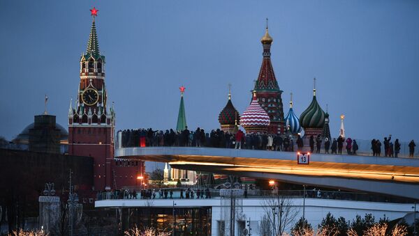 People visit Zaryadye Nature-Landscape Park in Moscow, Russia. Background from left: Spasskaya (Savior) Tower of the Moscow Kremlin and domes of Intercession of the Most Holy Theotokos on the Moat Cathedral (St. Basil's Cathedral) - Sputnik Afrique