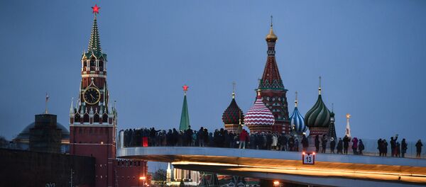 People visit Zaryadye Nature-Landscape Park in Moscow, Russia. Background from left: Spasskaya (Savior) Tower of the Moscow Kremlin and domes of Intercession of the Most Holy Theotokos on the Moat Cathedral (St. Basil's Cathedral) - Sputnik Afrique