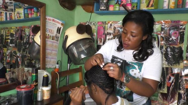Anastasie, coiffeuse, en pleine séance de pose d’extensions naturelles. Cameroun Anastasie, coiffeuse, en pleine séance de pose d’extensions naturelles. Cameroun - Sputnik Afrique