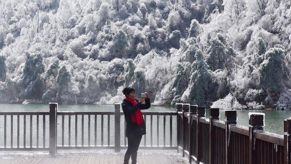woman takes a picture of the snow and ice in Hangzhou in eastern China's Zhejiang province on January 25, 2016. - Sputnik Afrique