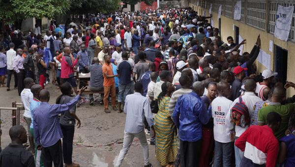 Hundreds of Congolese voters who have been waiting at the St. Raphael school in the Limete district of Kinshasa Sunday Dec. 30, 2018, storm the polling stations after the voters listings were finally posted five hours after the official start of voting. Forty million voters are registered for a presidential race plagued by years of delay and persistent rumors of lack of preparation. (AP Photo/Jerome Delay) - Sputnik Afrique