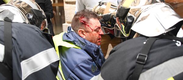 A protester wearing a Yellow Vest (Gilet Jaune) receives first aid after he was injured by a rubber ball shot by a non-lethal hand-held weapon (LBD40) during an anti-government - Sputnik Afrique