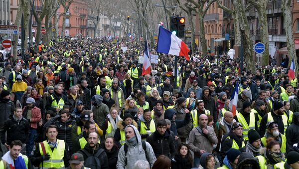 Protestors wearing Yellow Vests (gilets jaunes) hold French flags as they take part in an anti-government demonstration called by the Yellow Vest movement on January 12, 2019, - Sputnik Afrique