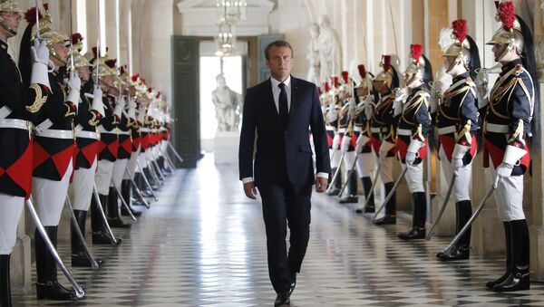 French President Emmanuel Macron walks through the Galerie des Bustes (Busts Gallery) to access the Versailles Palace's hemicycle to address both the upper and lower houses of the French parliament at a special session in Versailles, near Paris, Monday, July 9, 2018. - Sputnik Afrique