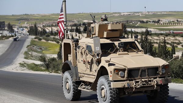 A U.S. soldier sits on an armored vehicle on a road leading to the tense front line with Turkish-backed fighters, in Manbij, north Syria, Wednesday, April 4, 2018 - Sputnik Afrique