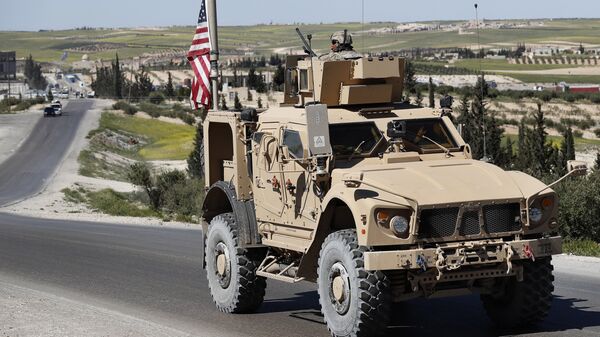 A U.S. soldier sits on an armored vehicle on a road leading to the tense front line with Turkish-backed fighters, in Manbij, north Syria, Wednesday, April 4, 2018 - Sputnik Afrique