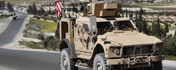 A U.S. soldier sits on an armored vehicle on a road leading to the tense front line with Turkish-backed fighters, in Manbij, north Syria, Wednesday, April 4, 2018 - Sputnik Afrique