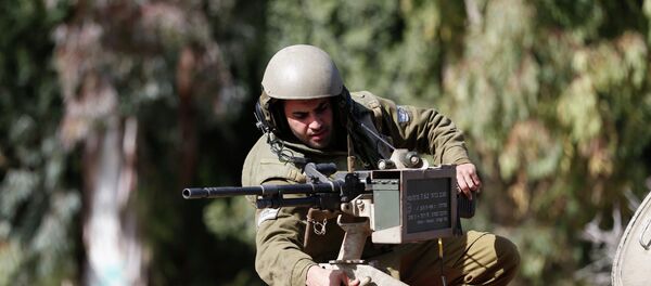 An Israeli soldier adjusts a weapon atop an armoured military ambulance near Israel's border with Lebanon - Sputnik Afrique