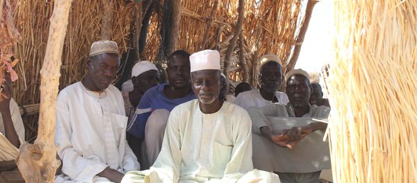 Des hommes assis dans un arbri en matériau provisoire au camp des déplacés de Igawa Mémé, Extrême-Nord, Cameroun - Sputnik Afrique