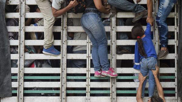 Венесуэльские мигранты лезут в грузовик на дороге из Кукуты в Памплону, Колумбия - Sputnik Afrique