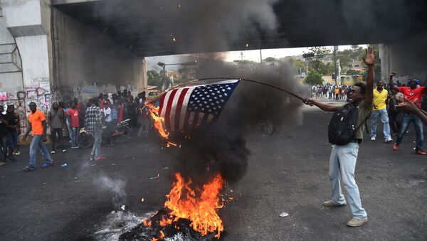 Des manifestants haïtiens brûlent un drapeau américain et appellent à l’aide la Russie - Sputnik Afrique