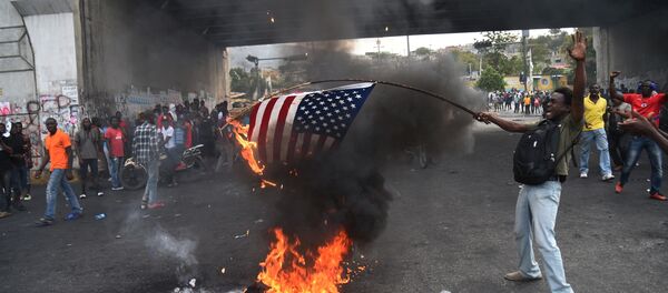 Des manifestants haïtiens brûlent un drapeau américain et appellent à l’aide la Russie - Sputnik Afrique