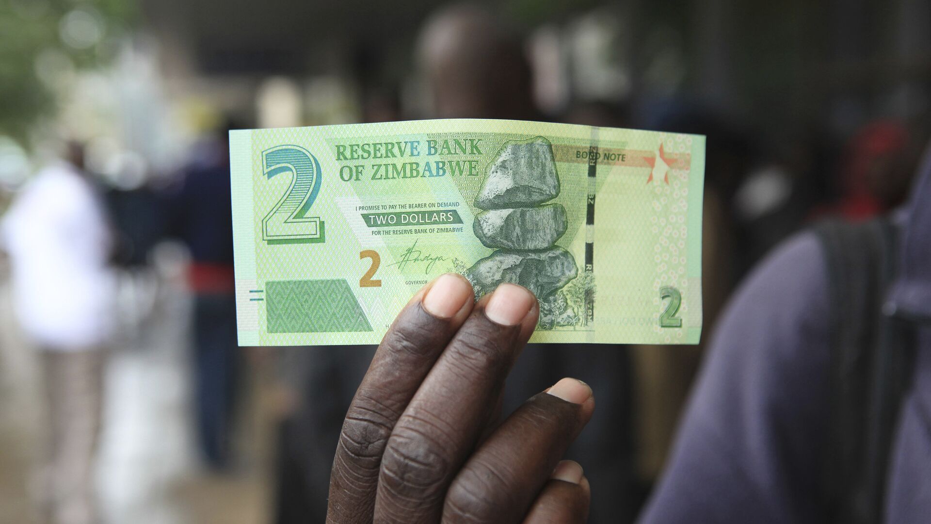 Un homme montre un nouveau billet de la Bank of Zimbabwe à Harare - Sputnik Afrique, 1920, 20.02.2023