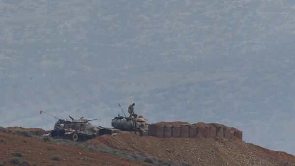 Soldiers man a Turkish Army artillery position, as seen from the outskirts of the village of Sugedigi, Turkey, near the border with Syria, background - Sputnik Afrique
