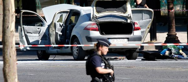 Police secure the area near a burned car at the scene of an incident in which it rammed a gendarmerie van on the Champs-Elysees Avenue in Paris, France, June 19, 2017 - Sputnik Afrique