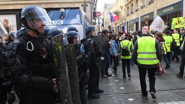 Protestor walk by riot police officers during an anti-government demonstration called by the Yellow Vests (gilets jaunes) movement on March 2, 2019 in Bordeaux, - Sputnik Afrique