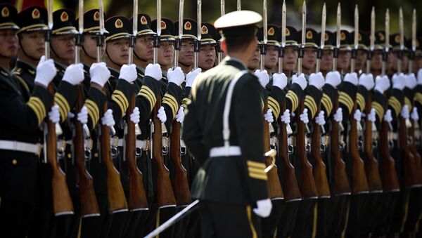 A Chinese People's Liberation Army soldier watches the position of members of a guard of honor as they prepare for a welcome ceremony for visiting Indian Prime Minister Manmohan Singh, outside the Great Hall of the People in Beijing Wednesday, Oct. 23, 2013. - Sputnik Afrique