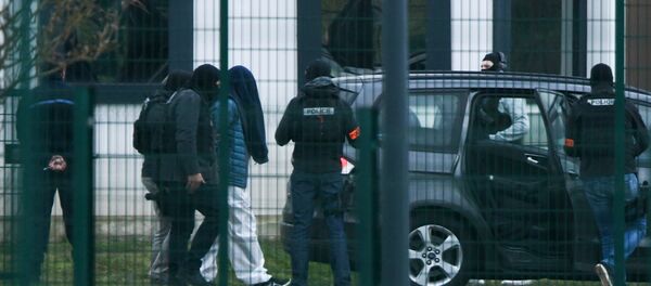 Des policiers conduisent une personne menottée au centre pénitentiaire de Condé-sur-Sarthe - Sputnik Afrique