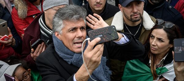 Algerian businessman and political activist Rachid Nekkaz (C) argues with Algerians in front of the Geneva University Hospitals (HUG) buildings in Geneva on March 8, 2019 - Sputnik Afrique