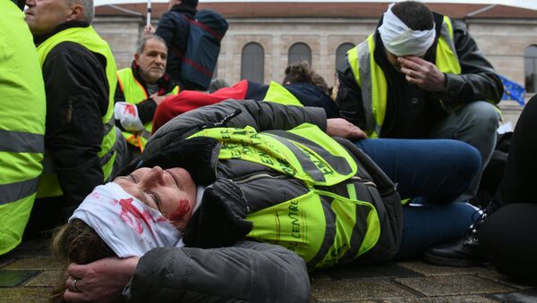 A protester with fake head injuries lays down the street during an anti-government demonstration called by the Yellow Vests (Gilets jaunes) and the White Coats (Blouses blanches) in Besancon, eastern France, on March - Sputnik Afrique