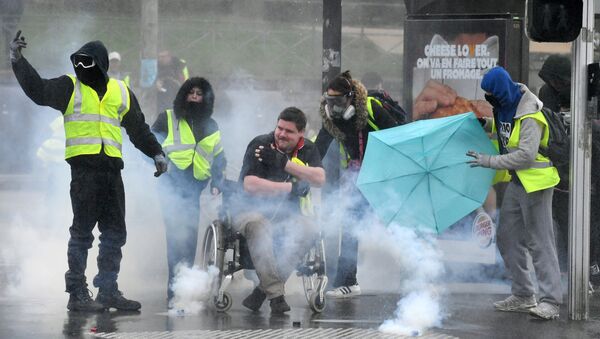 Protesters wearing a Yellow vests (Gilets Jaunes) stand amid smoke during a protest on March 9, 2019 in Quimper, western France. - Sputnik Afrique
