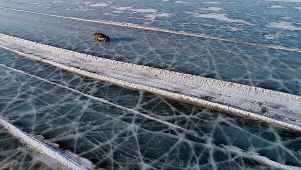 A car drives along a road connecting the banks of the ice-covered Yenisei River south of Krasnoyarsk - Sputnik Afrique