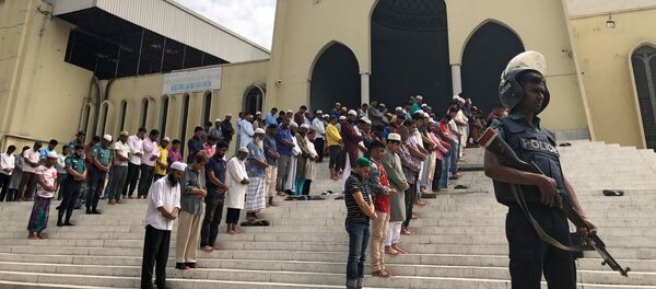 A police officer stands guard during Friday prayers at the Baitul Mukarram National Mosque, providing extra security after the Christchurch mosque attacks in New Zealand, in Dhaka, Bangladesh, March 15, 2019. - Sputnik Afrique