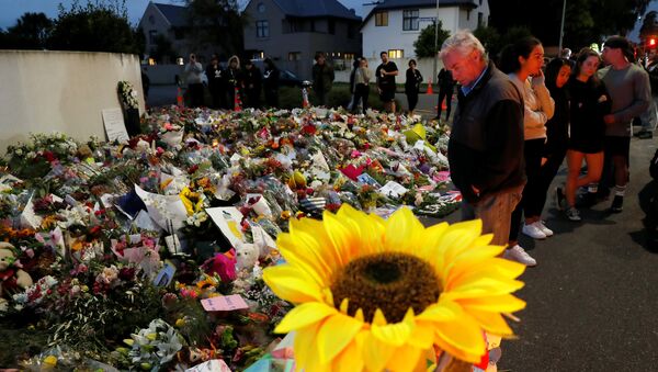 People visit a memorial site for victims of Friday's shooting, in front of the Masjid Al Noor mosque in Christchurch - Sputnik Afrique
