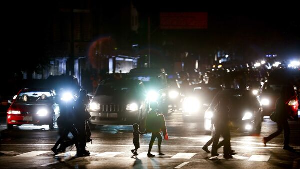 Residents cross a street in the dark after a power outage in Caracas, Venezuela, Thursday, March 7, 2019. A power outage left much of Venezuela in the dark early Thursday evening in what appeared to be one of the largest blackouts yet in a country where power failures have become increasingly common. Crowds of commuters in capital city Caracas were walking home after metro service ground to a halt and traffic snarled as cars struggled to navigate intersections where stoplights were out. - Sputnik Afrique