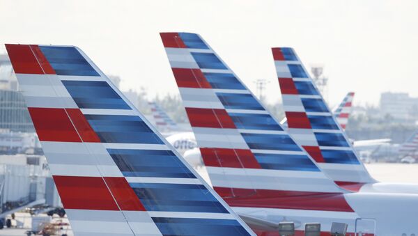 Painted vertical stabilizers are viewed as American Airlines jets are parked on the airport apron, Monday, Nov. 6, 2017, at Miami International Airport in Miami. American Airlines and a subsidiary will pay $9.8 million in stock to settle claims that they failed to help disabled employees return to work. - Sputnik Afrique